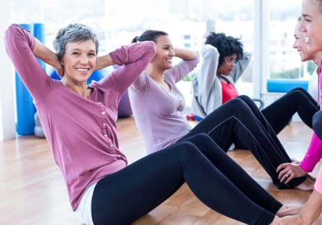 Portrait,Of,Woman,Doing,Sit,Ups,With,Friends,At,Fitness